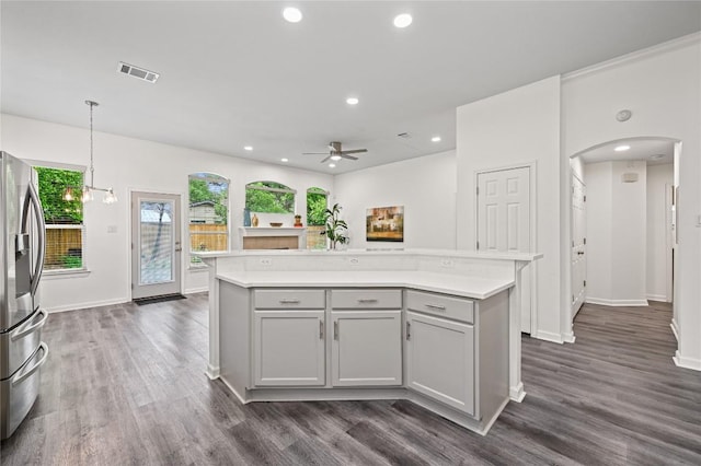 8721 Little Laura Dr, Austin, TX 78757 - kitchen featuring stainless steel fridge, arched walkways, light countertops, ceiling fan, and gray cabinets
