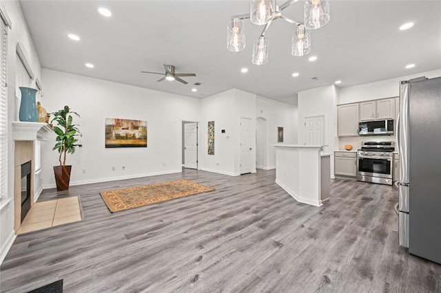 8721 Little Laura Dr, Austin, TX 78757 - unfurnished living room with a ceiling fan, a fireplace with flush hearth, recessed lighting, arched walkways, and wood finished floors
