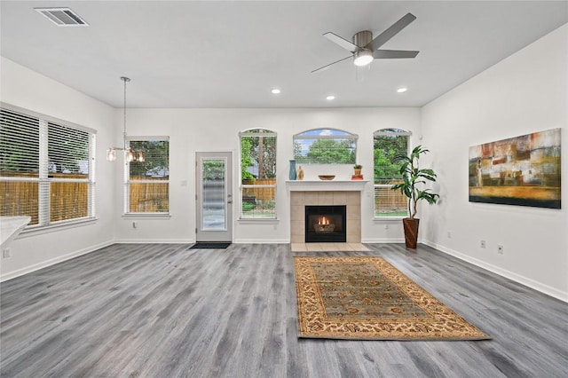 8721 Little Laura Dr, Austin, TX 78757 - unfurnished living room featuring wood finished floors, ceiling fan, a tiled fireplace, and recessed lighting