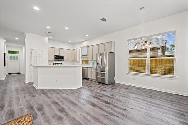 8721 Little Laura Dr, Austin, TX 78757 - kitchen featuring appliances with stainless steel finishes, light countertops, wood finished floors, a chandelier, and a kitchen island