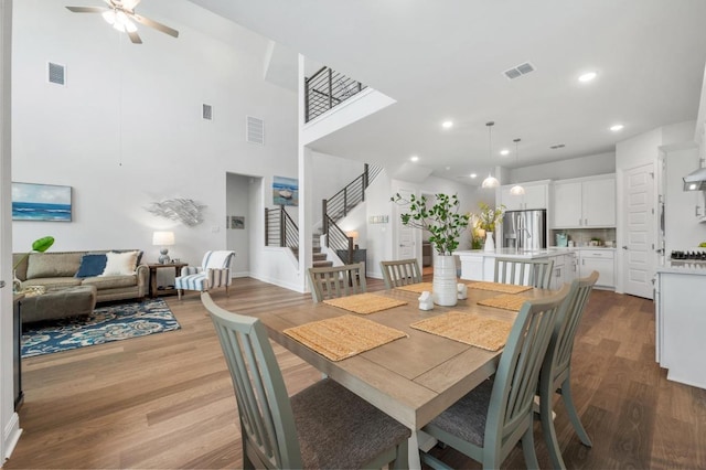 913 Landing Ln, Leander, TX 78641 - dining room with stairway, wood finished floors, a ceiling fan, recessed lighting, and a towering ceiling