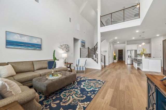 913 Landing Ln, Leander, TX 78641 - living area with stairway, light wood-type flooring, recessed lighting, and a towering ceiling