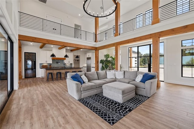 4100 Peak Look Out Dr, Austin, TX 78738 - living room with a chandelier, light wood finished floors, a high ceiling, and recessed lighting