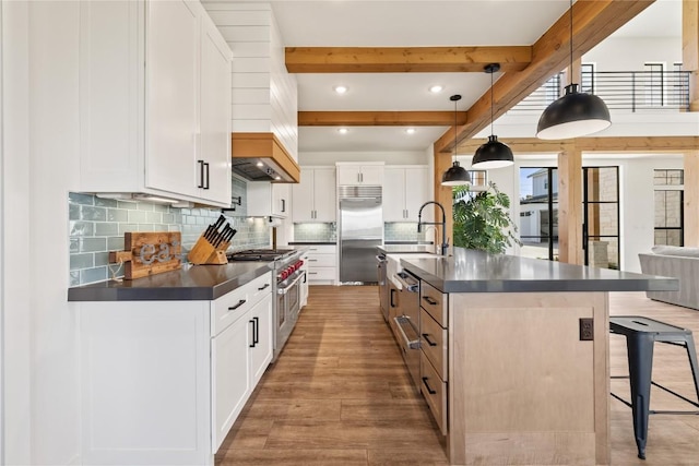 4100 Peak Look Out Dr, Austin, TX 78738 - kitchen featuring high end appliances, dark countertops, a kitchen breakfast bar, light wood-style flooring, and beamed ceiling