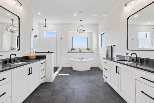 4100 Peak Look Out Dr, Austin, TX 78738 - bathroom with a shower stall, two vanities, recessed lighting, a soaking tub, and a wainscoted wall