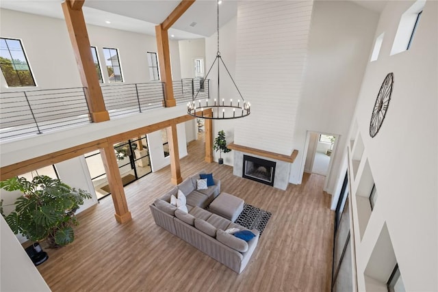 4100 Peak Look Out Dr, Austin, TX 78738 - living room featuring a high ceiling, wood finished floors, a chandelier, a fireplace, and recessed lighting