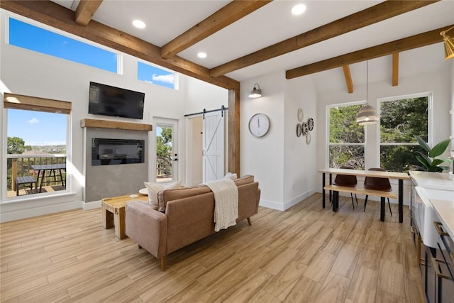 4100 Peak Look Out Dr, Austin, TX 78738 - living area featuring a barn door, beamed ceiling, light wood-style floors, recessed lighting, and a glass covered fireplace