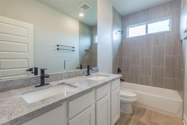103 Periwinkle Ln, Bastrop, TX 78602 - full bathroom featuring double vanity, tub / shower combination, and wood finished floors