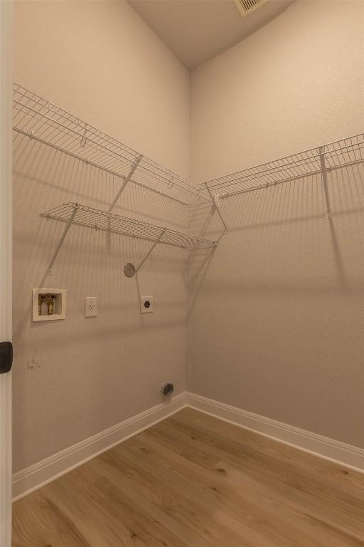 103 Periwinkle Ln, Bastrop, TX 78602 - washroom with wood finished floors, hookup for an electric dryer, and hookup for a washing machine