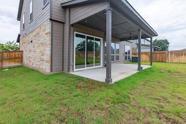 103 Periwinkle Ln, Bastrop, TX 78602 - back of house with stone siding, a patio area, and a fenced backyard