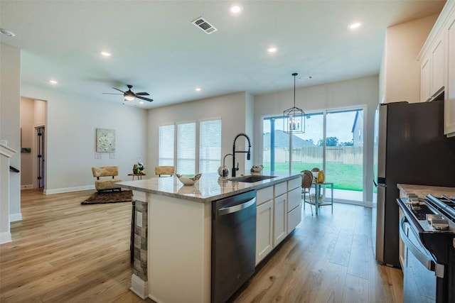 103 Periwinkle Ln, Bastrop, TX 78602 - kitchen featuring stainless steel appliances, white cabinets, light wood finished floors, a ceiling fan, and recessed lighting