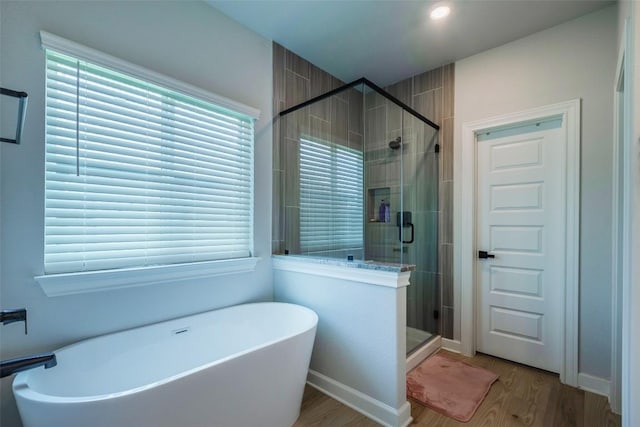 126 Periwinkle Ln, Bastrop, TX 78602 - bathroom with wood finished floors, a soaking tub, and a stall shower