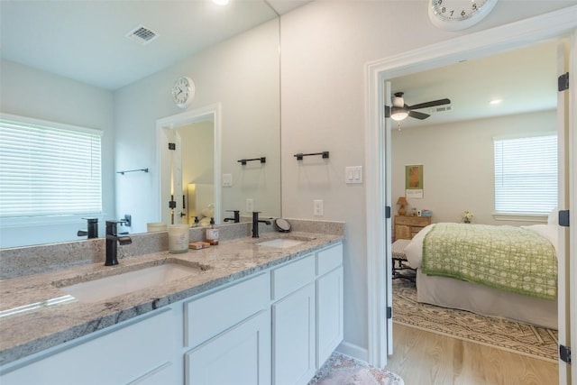 126 Periwinkle Ln, Bastrop, TX 78602 - ensuite bathroom featuring double vanity, healthy amount of natural light, a ceiling fan, wood finished floors, and recessed lighting