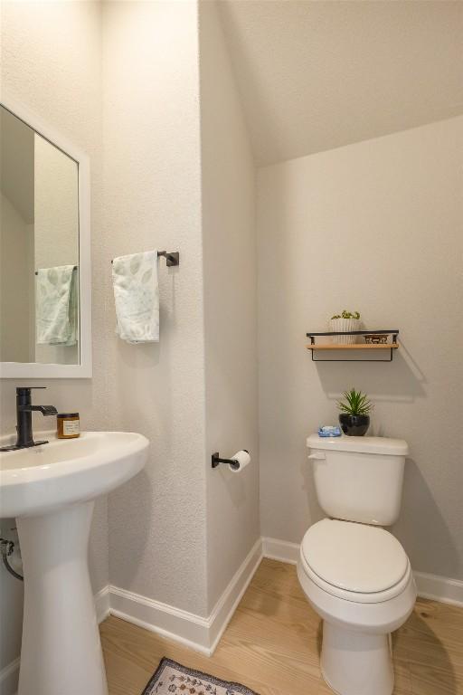126 Periwinkle Ln, Bastrop, TX 78602 - half bathroom featuring wood finished floors and vaulted ceiling