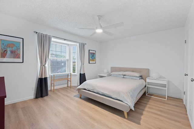 1240 Barton Hills Dr Unit 114, Austin, TX 78704 - bedroom with a textured ceiling, light wood-style floors, and ceiling fan