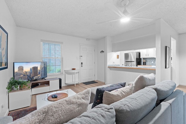 1240 Barton Hills Dr Unit 114, Austin, TX 78704 - living area featuring wood finished floors, a textured ceiling, and a ceiling fan