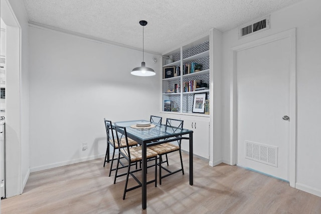 1240 Barton Hills Dr Unit 114, Austin, TX 78704 - dining area with a textured ceiling, light wood-style floors, and crown molding