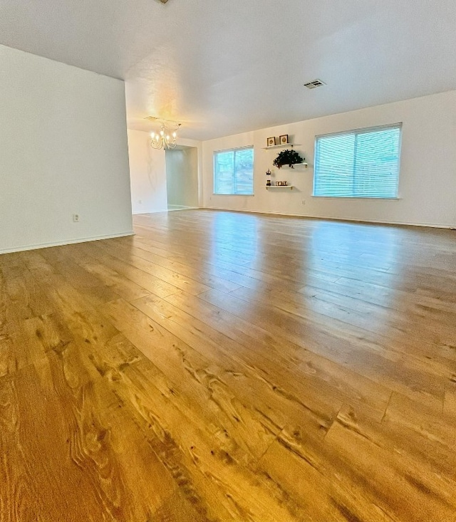108 Bexar Forest Cv, Elgin, TX 78621 - unfurnished living room with a chandelier and hardwood / wood-style floors