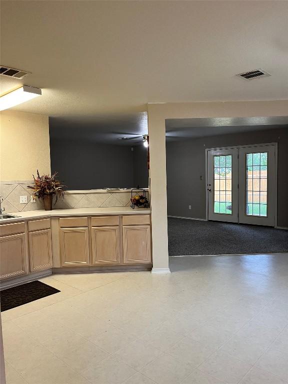 108 Bexar Forest Cv, Elgin, TX 78621 - kitchen with backsplash, french doors, and light countertops