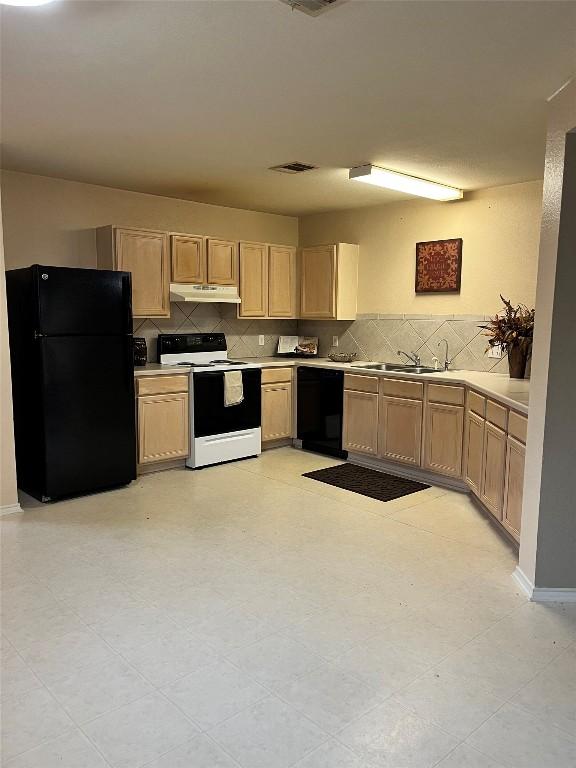 108 Bexar Forest Cv, Elgin, TX 78621 - kitchen with black appliances, under cabinet range hood, light brown cabinetry, and tasteful backsplash