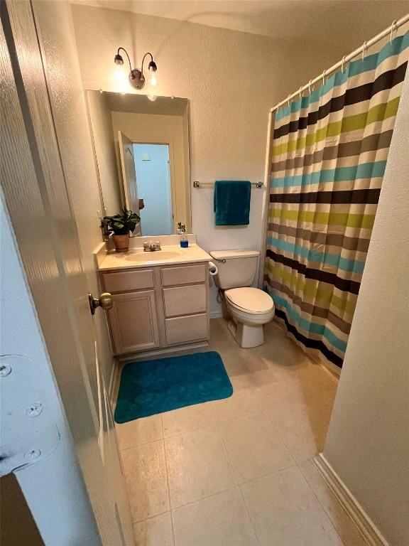 108 Bexar Forest Cv, Elgin, TX 78621 - bathroom with vanity, tile patterned floors, and curtained shower