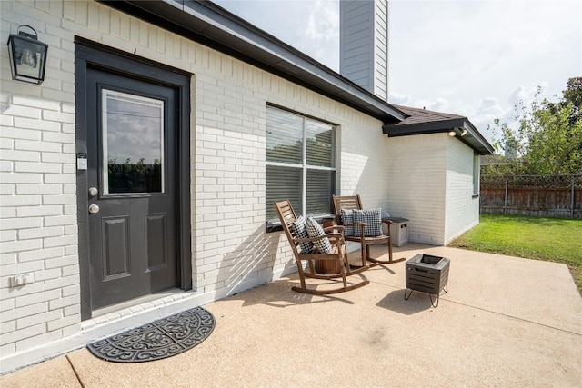 1410 Sherry Dr, Taylor, TX 76574 - property entrance with brick siding, a patio area, and a chimney