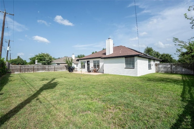 1410 Sherry Dr, Taylor, TX 76574 - rear view of house with a fenced backyard, a patio area, brick siding, a chimney, and a shingled roof