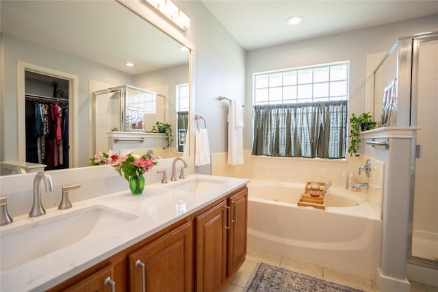 1410 Sherry Dr, Taylor, TX 76574 - bathroom featuring a stall shower, a bath, double vanity, a walk in closet, and recessed lighting