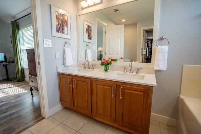 1410 Sherry Dr, Taylor, TX 76574 - full bath with double vanity, tile patterned flooring, and a tub to relax in