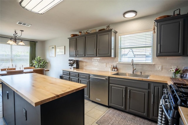 1410 Sherry Dr, Taylor, TX 76574 - kitchen featuring butcher block countertops, stainless steel dishwasher, range with gas stovetop, backsplash, and plenty of natural light