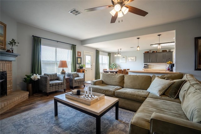 1410 Sherry Dr, Taylor, TX 76574 - living area featuring dark wood finished floors, ceiling fan, and a fireplace