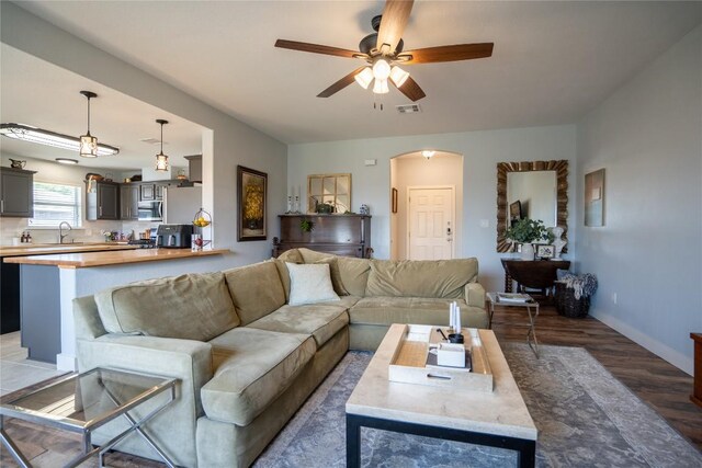 1410 Sherry Dr, Taylor, TX 76574 - living room with light wood-style flooring, ceiling fan, and arched walkways