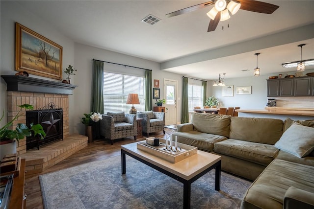 1410 Sherry Dr, Taylor, TX 76574 - living area featuring wood finished floors, a ceiling fan, and a fireplace