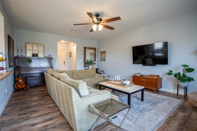 1410 Sherry Dr, Taylor, TX 76574 - living room with arched walkways, ceiling fan, and dark wood-type flooring