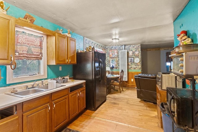 147 Sunset Hts, Bastrop, TX 78602 - kitchen featuring black refrigerator with ice dispenser, wallpapered walls, light wood finished floors, light countertops, and brown cabinets