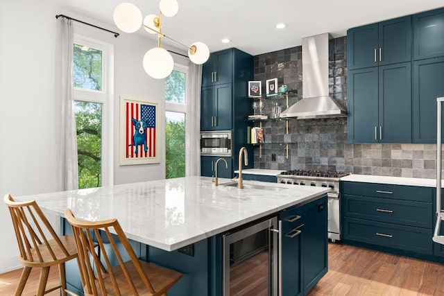 606 Augusta Ave Unit 1, Austin, TX 78703 - kitchen with wine cooler, island range hood, appliances with stainless steel finishes, backsplash, and light wood-style floors