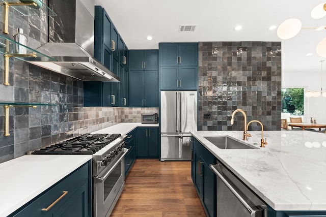 606 Augusta Ave Unit 1, Austin, TX 78703 - kitchen featuring high end appliances, ventilation hood, backsplash, blue cabinets, and recessed lighting