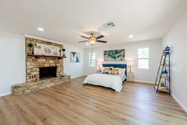106 Heron, Highland Haven, TX 78654 - bedroom featuring multiple windows, light wood finished floors, a stone fireplace, and recessed lighting
