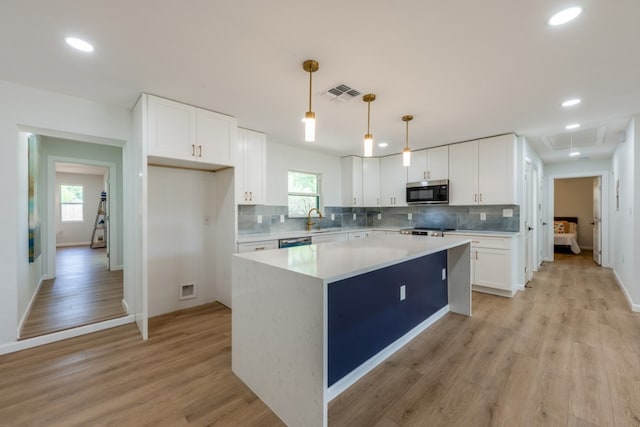 106 Heron, Highland Haven, TX 78654 - kitchen with appliances with stainless steel finishes, white cabinetry, recessed lighting, light wood-style floors, and backsplash