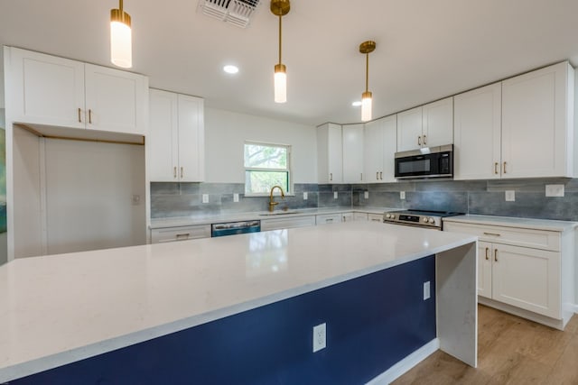 106 Heron, Highland Haven, TX 78654 - kitchen featuring stainless steel appliances, light wood-style floors, white cabinets, and recessed lighting