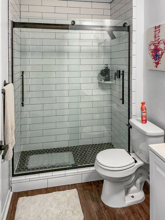 6100 Calmar Cv, Austin, TX 78721 - bathroom with wood finished floors, a shower stall, vanity, and a textured wall