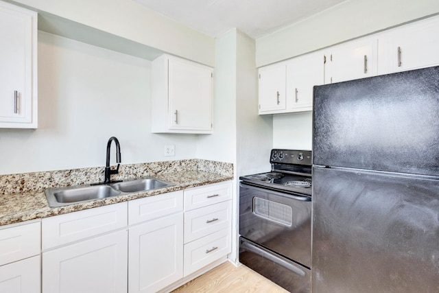6100 Calmar Cv, Austin, TX 78721 - kitchen featuring black appliances, white cabinetry, light stone counters, and light wood finished floors