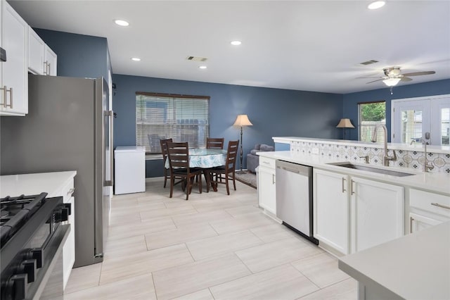 207 Presidio Dr, Leander, TX 78641 - kitchen featuring dishwasher, ceiling fan, gas range, white cabinets, and light countertops