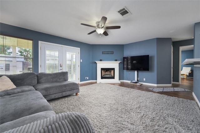 207 Presidio Dr, Leander, TX 78641 - living area with wood finished floors, ceiling fan, and a fireplace with raised hearth