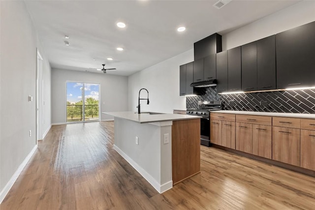 4510 Terry-O Ln Unit 415, Austin, TX 78745 - kitchen featuring gas range, an island with sink, tasteful backsplash, ceiling fan, and light wood finished floors