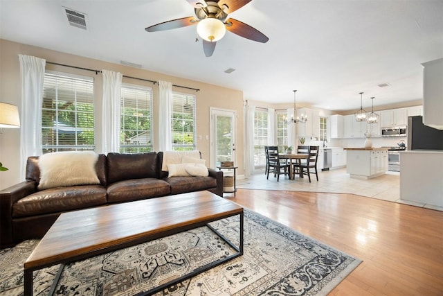 1215 Boerne Dr, Cedar Park, TX 78613 - living room with a chandelier, ceiling fan, and light wood-style floors