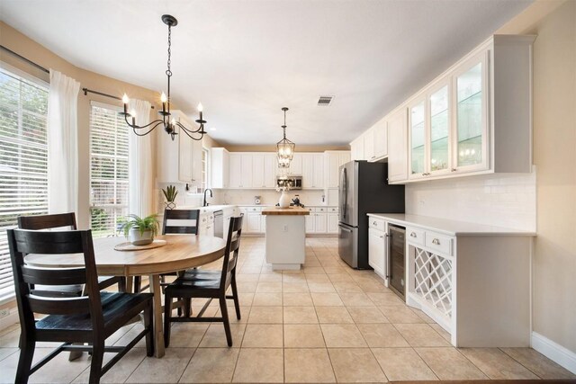 1215 Boerne Dr, Cedar Park, TX 78613 - dining room featuring a chandelier, healthy amount of natural light, light tile patterned floors, and beverage cooler