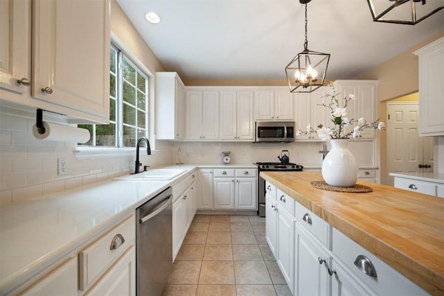 1215 Boerne Dr, Cedar Park, TX 78613 - kitchen featuring appliances with stainless steel finishes, wooden counters, tasteful backsplash, and white cabinetry