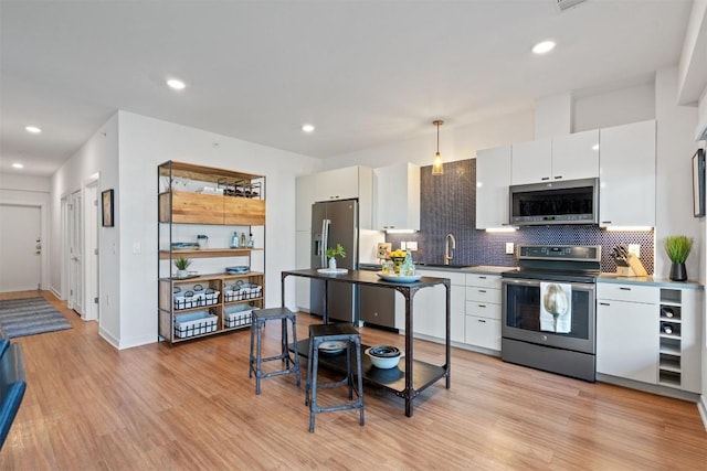 4361 S Congress Ave Unit 435, Austin, TX 78745 - kitchen with appliances with stainless steel finishes, decorative backsplash, light wood-style floors, white cabinets, and recessed lighting