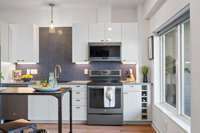 4361 S Congress Ave Unit 435, Austin, TX 78745 - kitchen with stainless steel appliances, white cabinets, tasteful backsplash, and pendant lighting